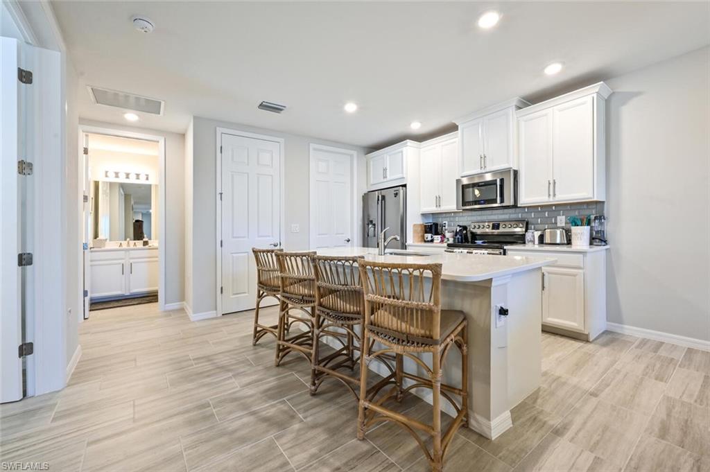 14680 Edgewater Circle Naples, FL 34114 - Photo 12 of 21 a kitchen with kitchen island granite countertop a sink and counter space