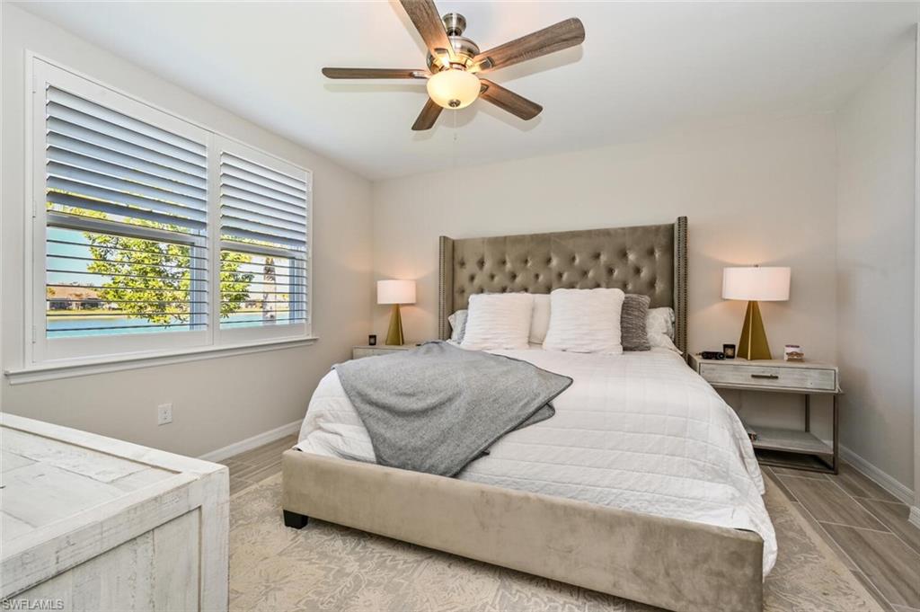 14680 Edgewater Circle Naples, FL 34114 - Photo 17 of 21 a bedroom with a bed and a chandelier