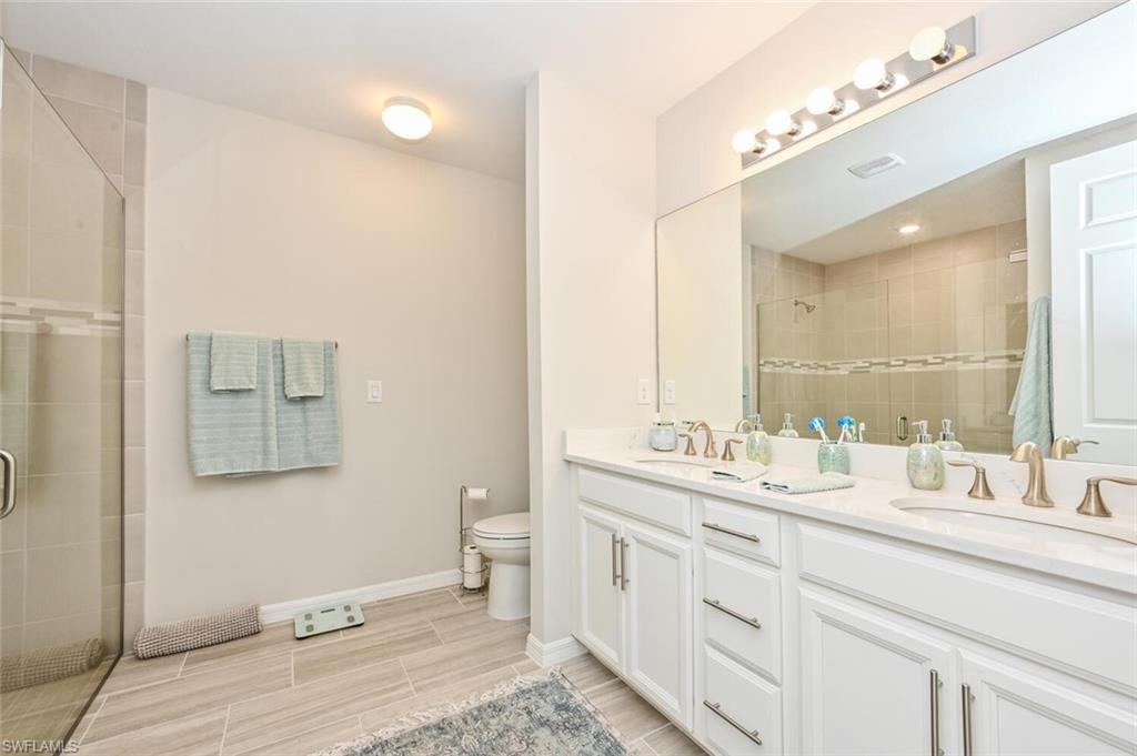 14680 Edgewater Circle Naples, FL 34114 - Photo 18 of 21 a bathroom with a double vanity sink mirror and toilet