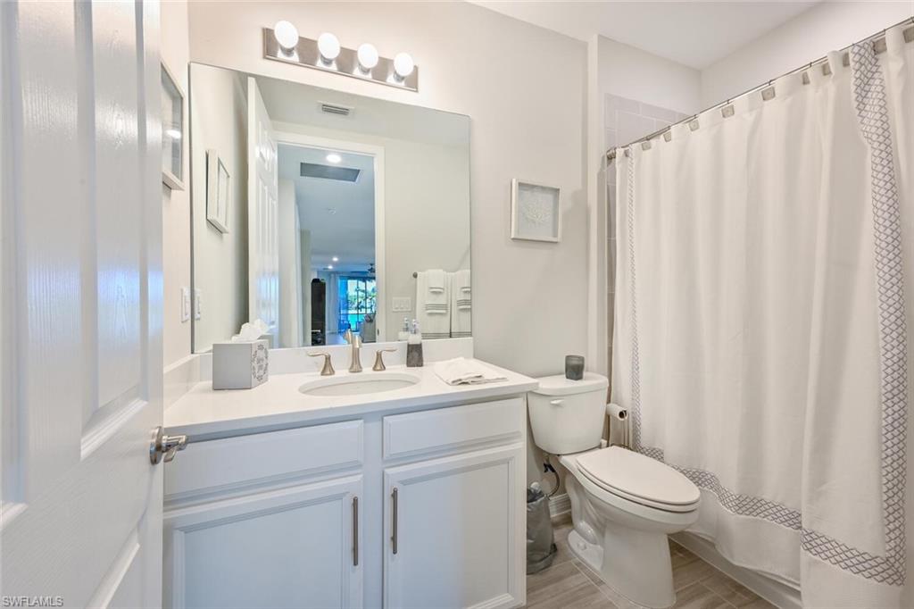 14680 Edgewater Circle Naples, FL 34114 - Photo 20 of 21 a bathroom with a toilet a sink and a mirror