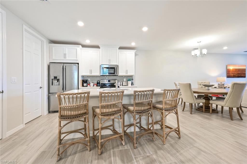 14680 Edgewater Circle Naples, FL 34114 - Photo 10 of 21 a view of a dining room with furniture and wooden floor