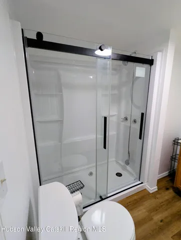 a view of room with hardwood floor and a ceiling fan