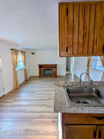 a kitchen with granite countertop wooden cabinets stainless steel appliances and a sink