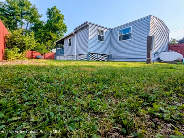 a view of yard with large tree and wooden fence