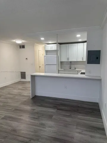 a kitchen with kitchen island sink and cabinets