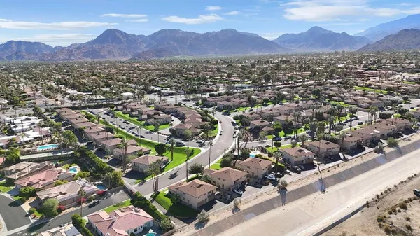 an aerial view of residential houses with outdoor space and trees
