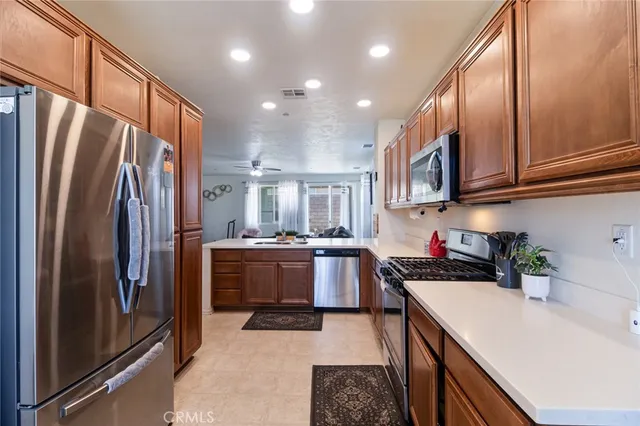 a kitchen with stainless steel appliances granite countertop a refrigerator stove top oven and sink
