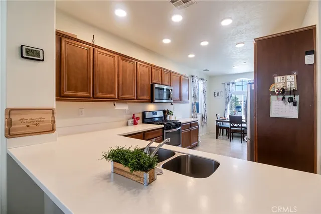 a kitchen with stainless steel appliances granite countertop a sink refrigerator and cabinets