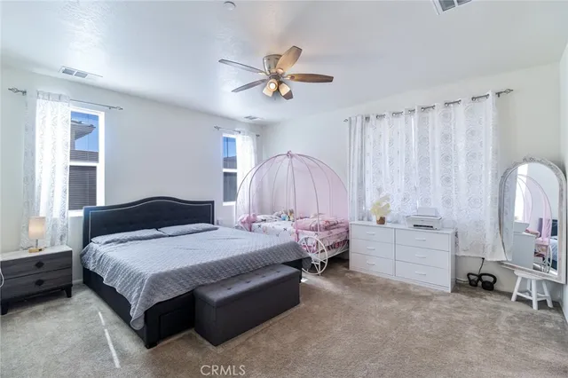 a spacious bedroom with a bed and a chandelier