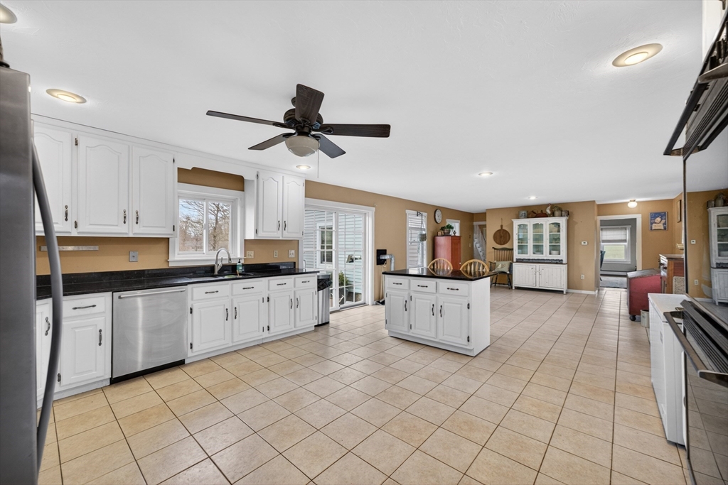 47 Singletary Avenue Sutton, MA 01590 - Photo 11 of 42 a large white kitchen with cabinets a sink a window and stainless steel appliances