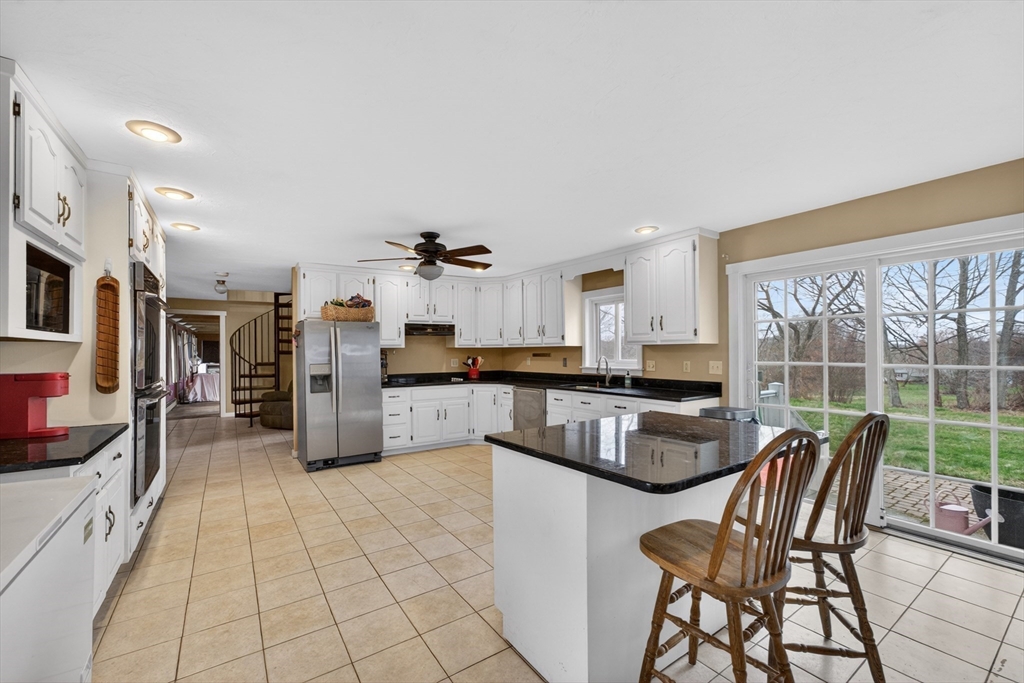 47 Singletary Avenue Sutton, MA 01590 - Photo 8 of 42 a kitchen with stainless steel appliances granite countertop a stove a refrigerator a kitchen island and chairs in it