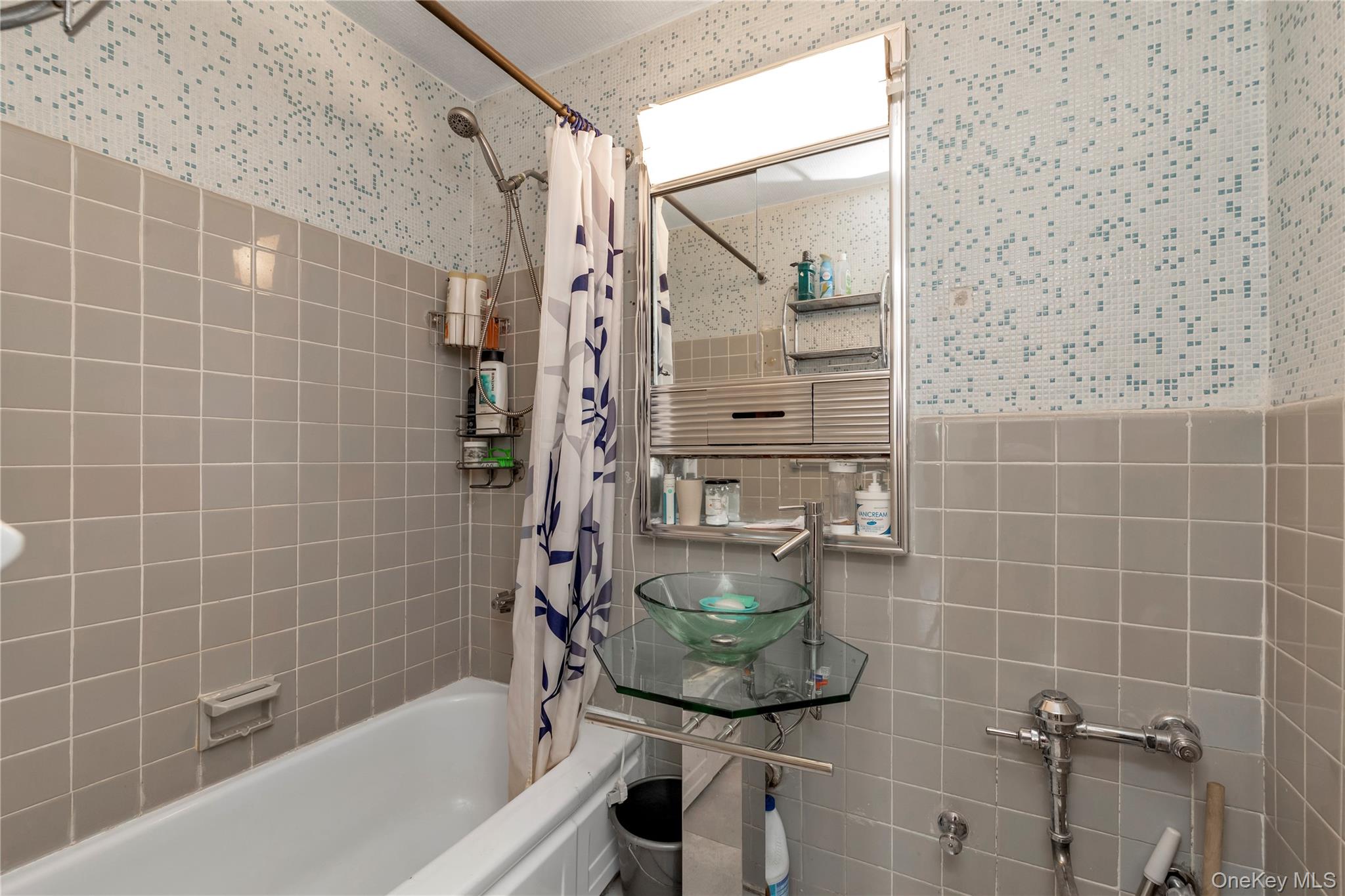 99-05 59th Avenue, Unit 6B Queens, NY 11368 - Photo 15 of 16 Bathroom featuring tile walls, shower / bath combo with shower curtain, and wallpapered walls