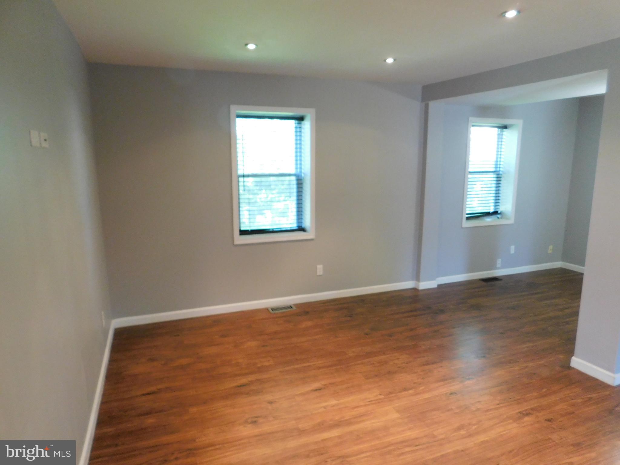 7009 Fieldcrest Road Baltimore, MD 21215 - Photo 8 of 46 an empty room with wooden floor and windows