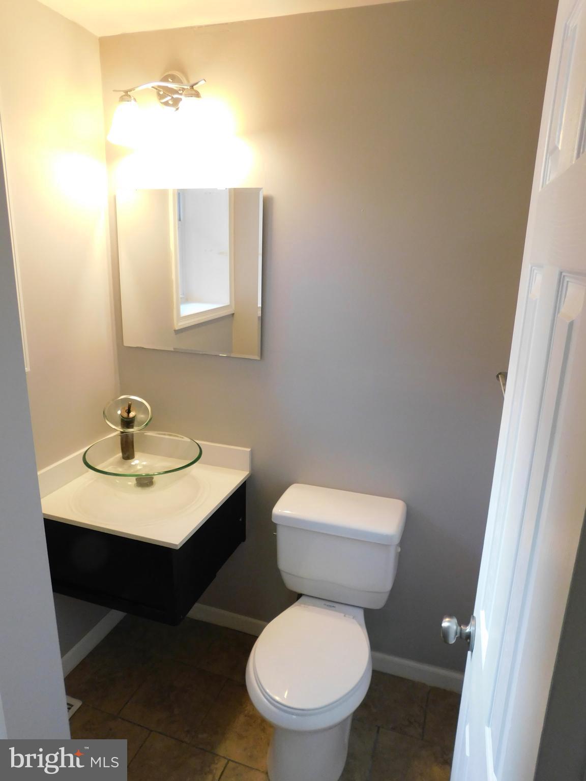 7009 Fieldcrest Road Baltimore, MD 21215 - Photo 10 of 46 a bathroom with a toilet a sink and mirror