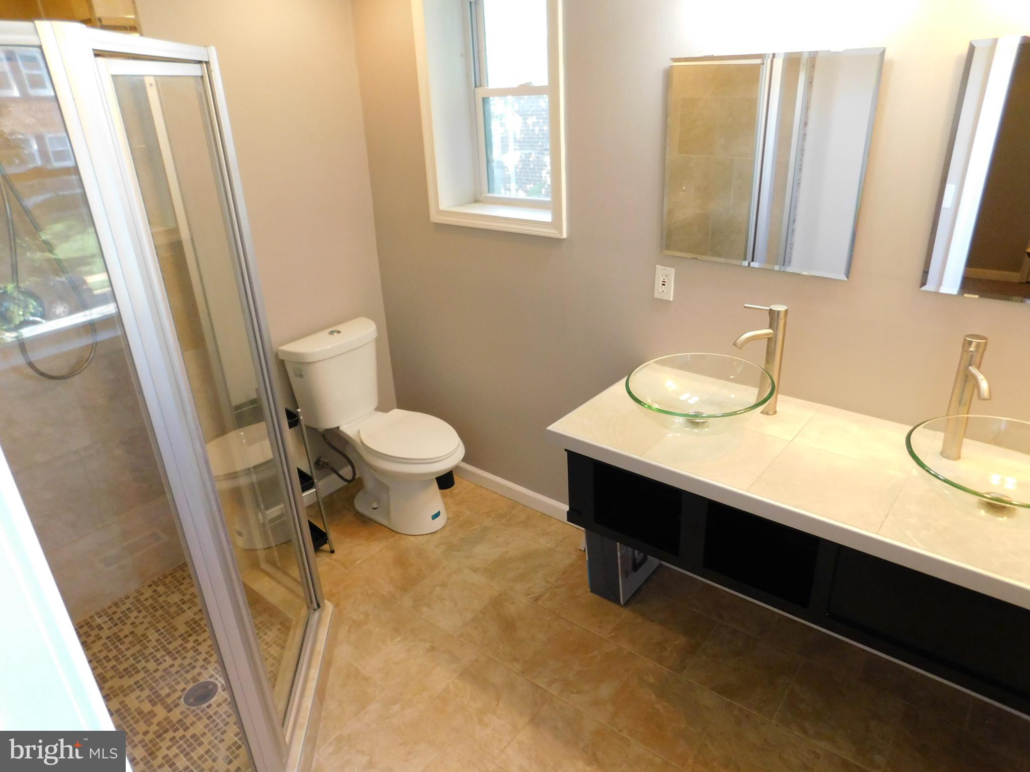 7009 Fieldcrest Road Baltimore, MD 21215 - Photo 30 of 46 a bathroom with a sink a toilet and a mirror