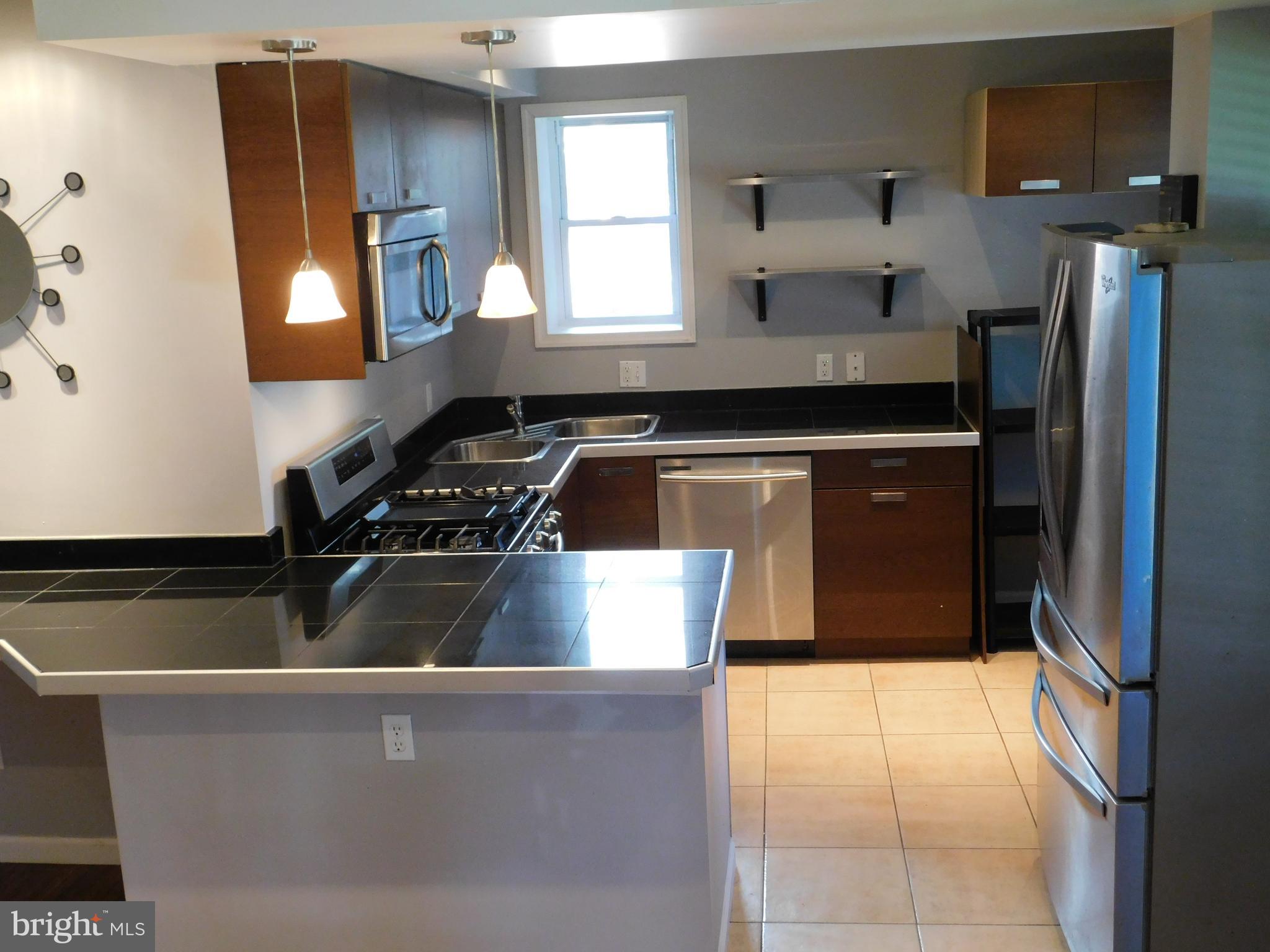 7009 Fieldcrest Road Baltimore, MD 21215 - Photo 4 of 46 a kitchen with granite countertop a refrigerator and a stove