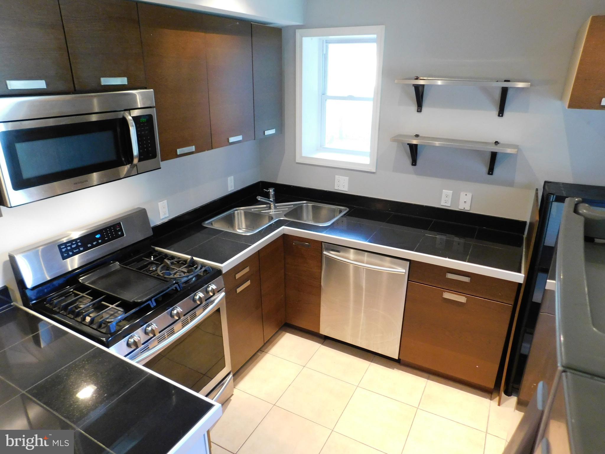 7009 Fieldcrest Road Baltimore, MD 21215 - Photo 5 of 46 a kitchen with kitchen island a sink stove and microwave