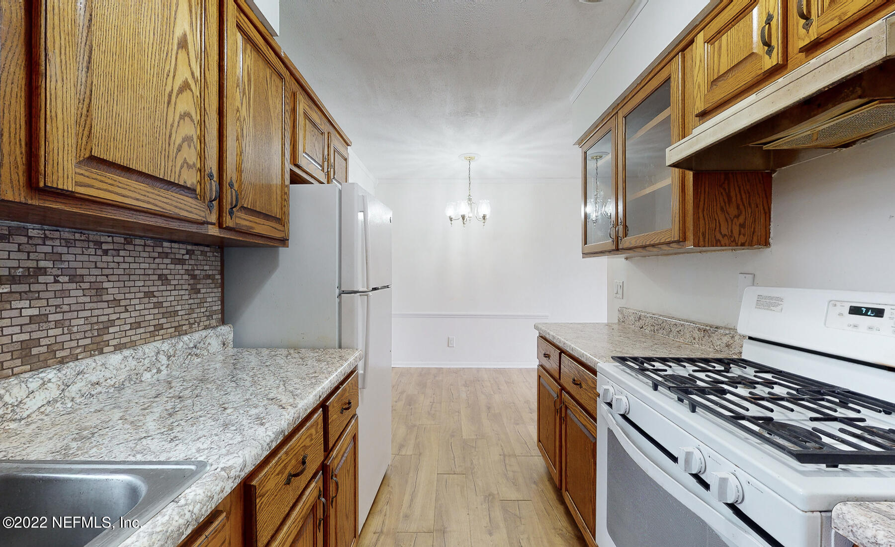 7403 Proxima Road Jacksonville, FL 32210 - Photo 18 of 30 a kitchen with kitchen island granite countertop a stove and a sink