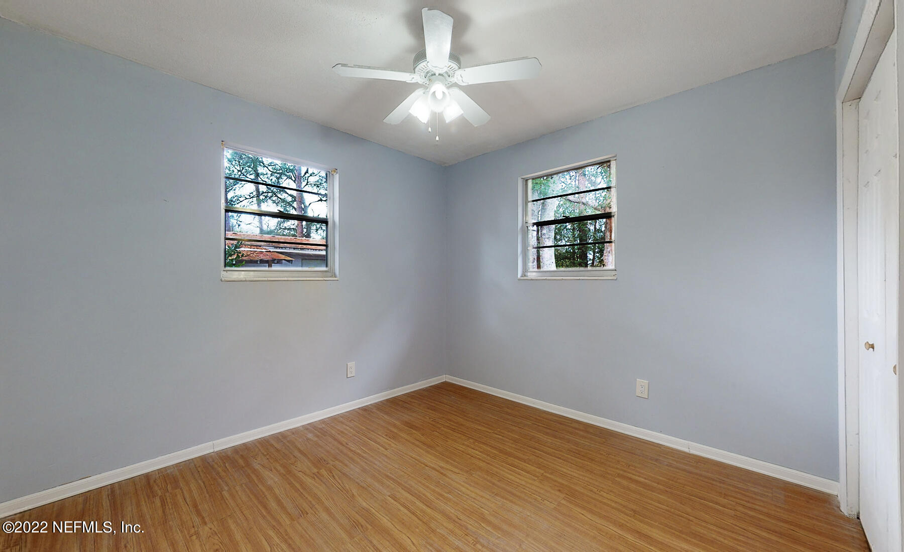 7403 Proxima Road Jacksonville, FL 32210 - Photo 22 of 30 an empty room with wooden floor and windows