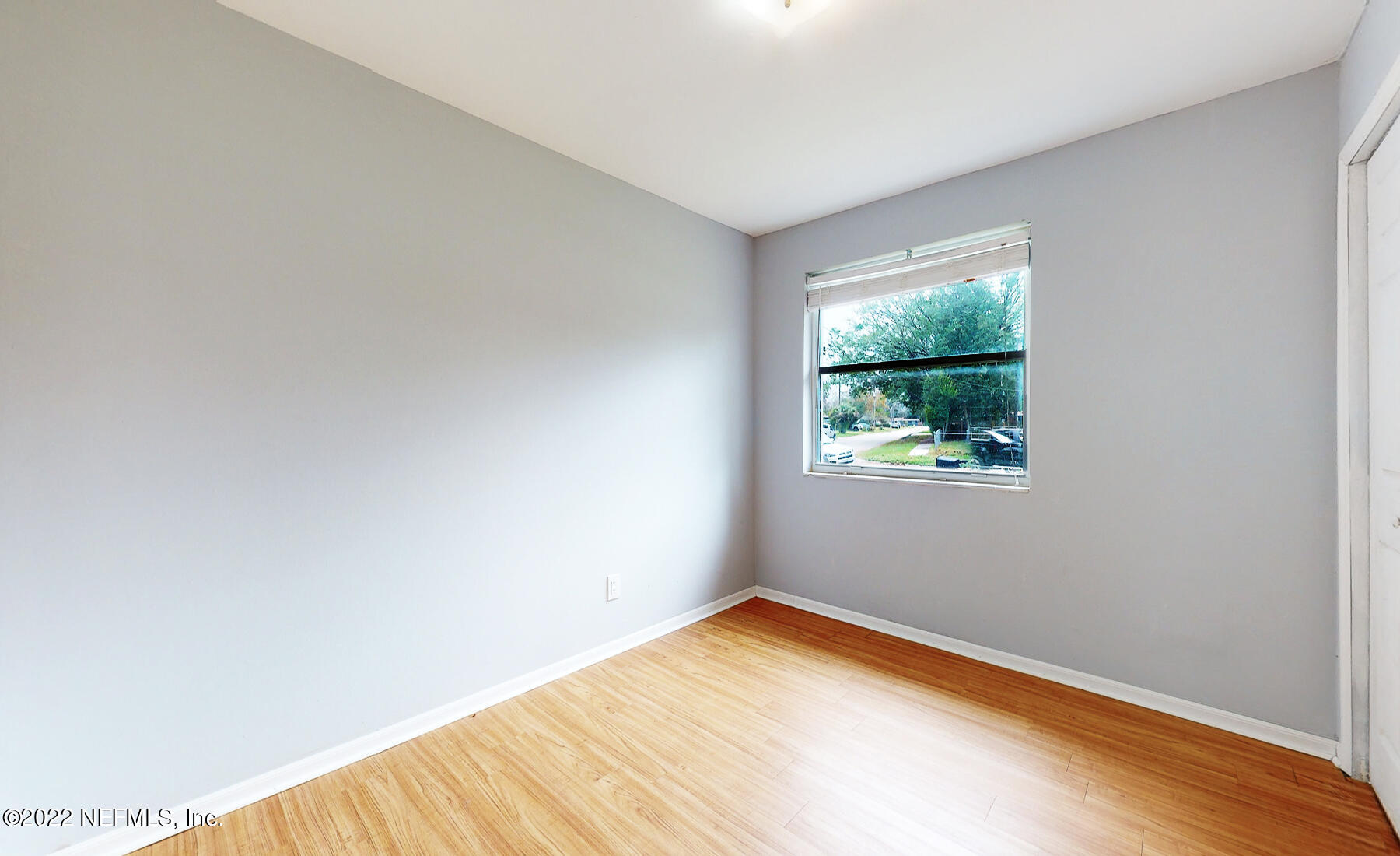 7403 Proxima Road Jacksonville, FL 32210 - Photo 8 of 30 a view of an empty room with wooden floor and a window