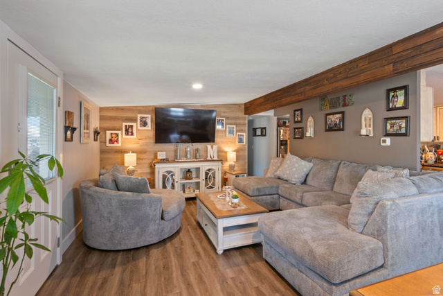 255 North 1600 West, Unit 60 Provo, UT 84601 - Photo 1 of 22 Living room featuring wooden walls, an accent wall, and wood finished floors