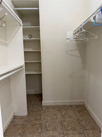 a view of walk in closet with empty racks