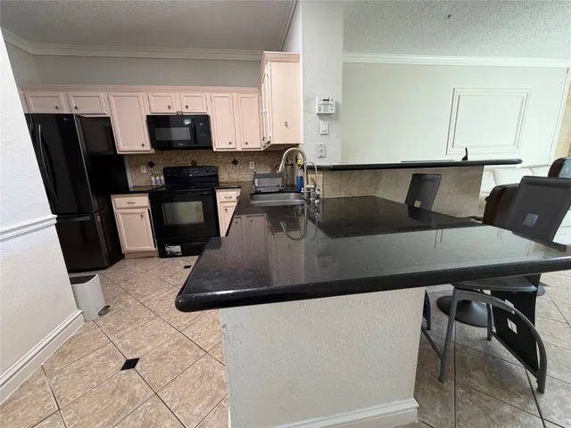 a kitchen with a table chairs microwave and sink