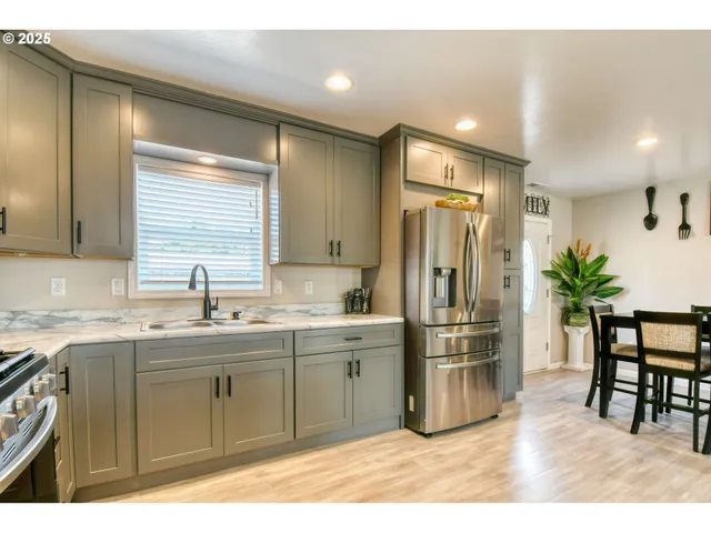 a kitchen with stainless steel appliances a sink and a refrigerator
