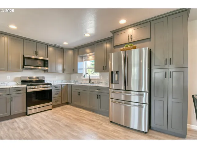 a kitchen with stainless steel appliances cabinets a sink and a refrigerator