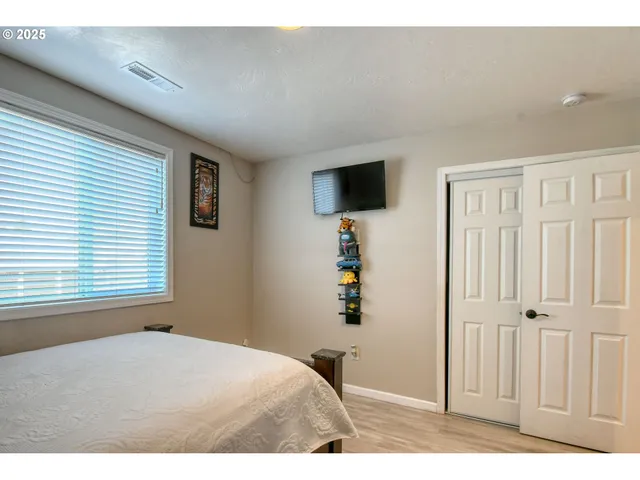 a bedroom with a bed and a flat screen tv