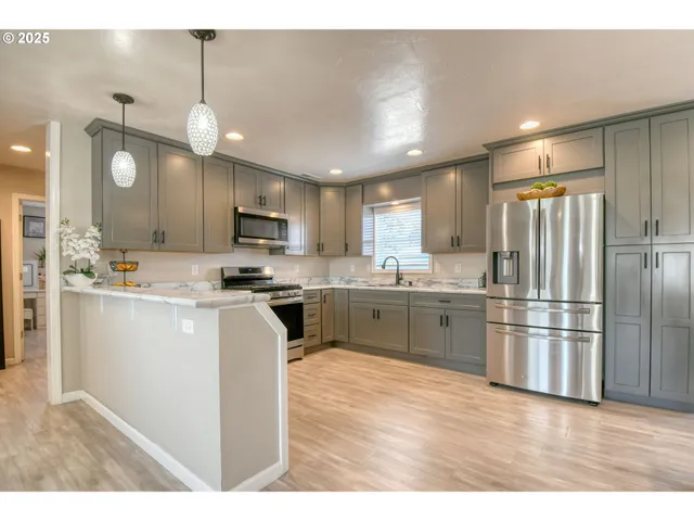 a kitchen with a refrigerator a sink and cabinets