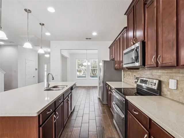 a kitchen with stainless steel appliances granite countertop a sink stove and cabinets