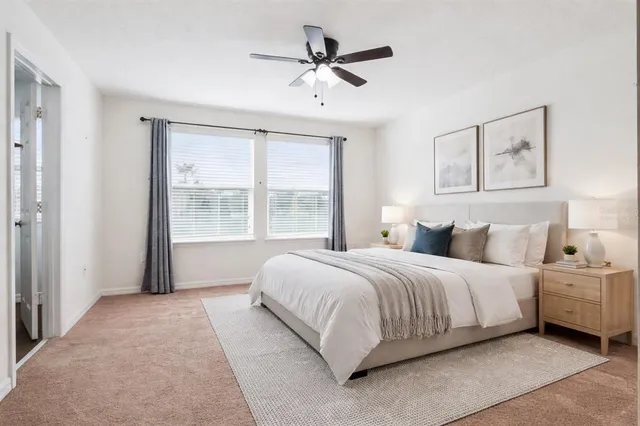 a spacious bedroom with a large bed and two large window