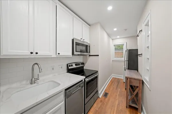 a kitchen with stainless steel appliances granite countertop a sink stove and refrigerator