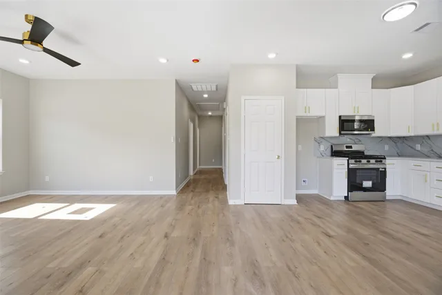 a view of kitchen with stainless steel appliances wooden floor and electronic appliances