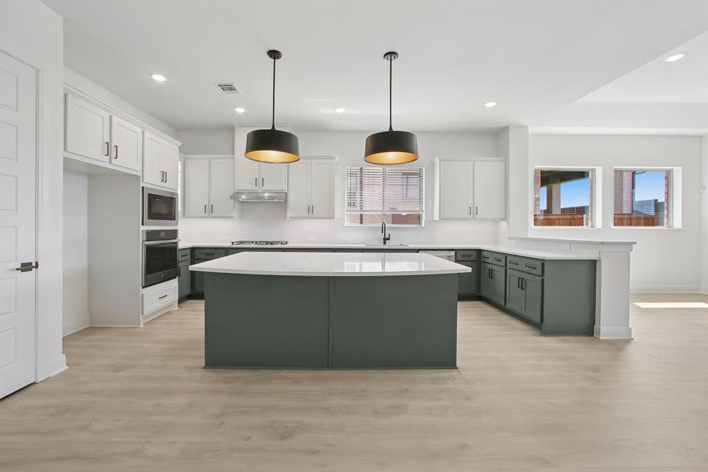 605 Derby Drive Mansfield, TX 76063 - Photo 11 of 13 a kitchen with stainless steel appliances granite countertop a sink a stove a refrigerator and island with wooden floor