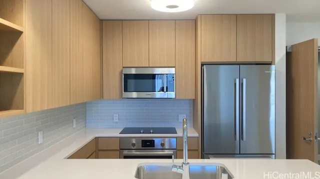 a kitchen with stainless steel appliances granite countertop a refrigerator and a stove