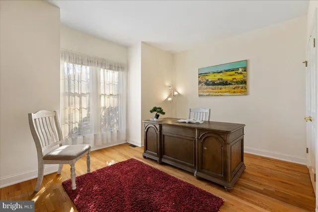 a view of a workspace with furniture and a window