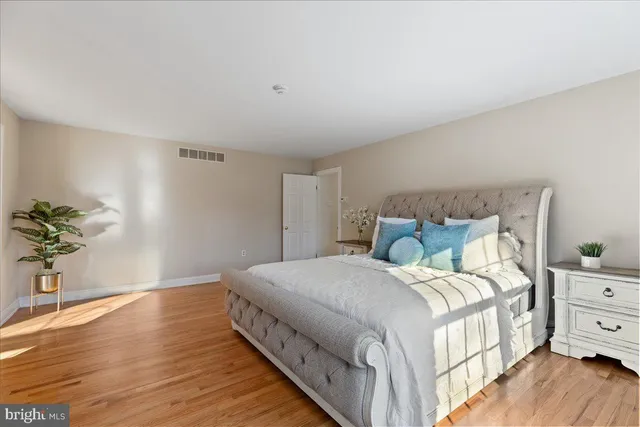 a bedroom with a bed and a potted plant