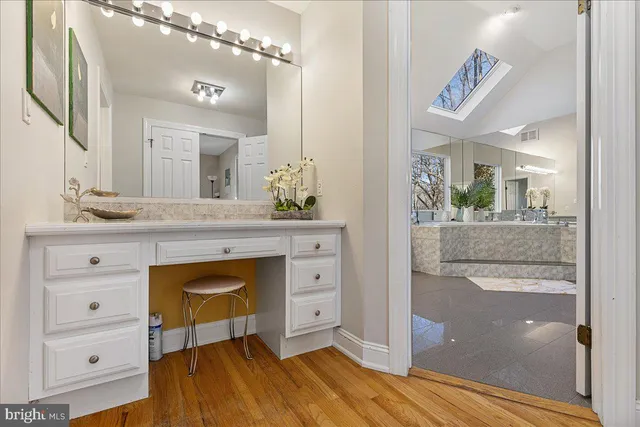 a spacious bathroom with a granite countertop sink mirror and vanity