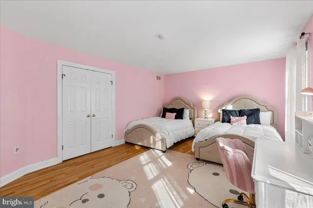 a bedroom with three beds and a window