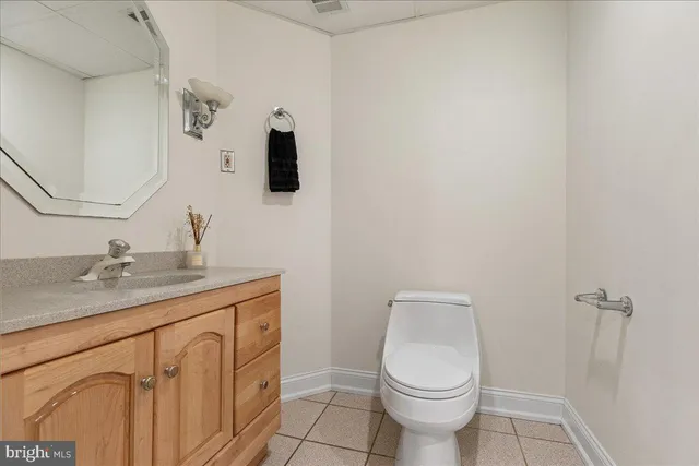 a bathroom with a granite countertop toilet sink and mirror