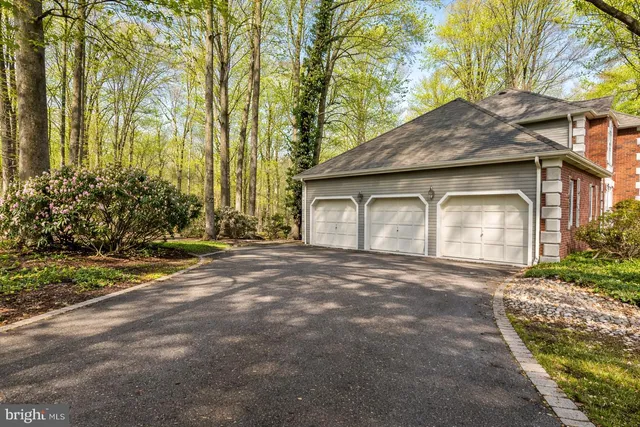 a front view of a house with a garden and trees