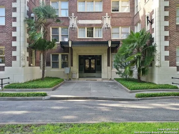 a front view of a house with garage and plants