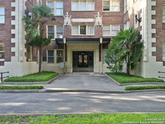 a front view of a house with garage and plants