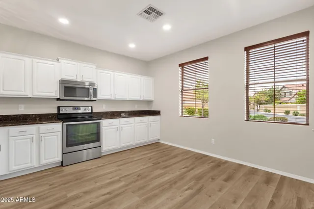 a kitchen with granite countertop a stove a sink and a microwave