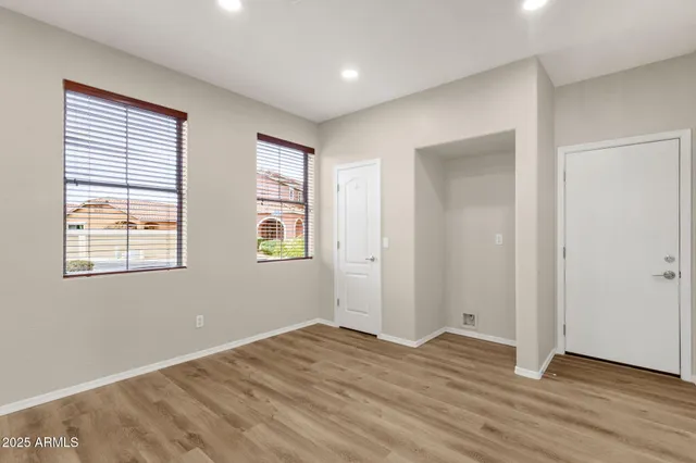 an empty room with wooden floor and windows