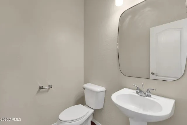 a bathroom with a sink mirror and toilet