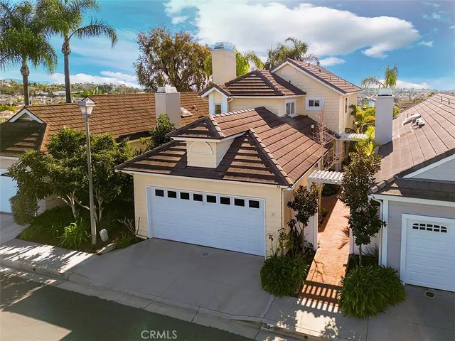 a front view of a house with a yard and palm trees