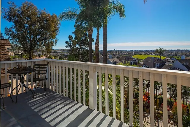 a view of a roof deck with table and chairs a barbeque with wooden floor and fence